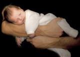 bebê deitado sobre o braço do pai
